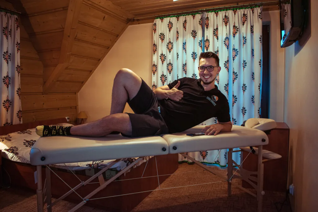 Karol Sobczyk leży na składanym stole do masażu w góralskim pokoju w Zakopanem