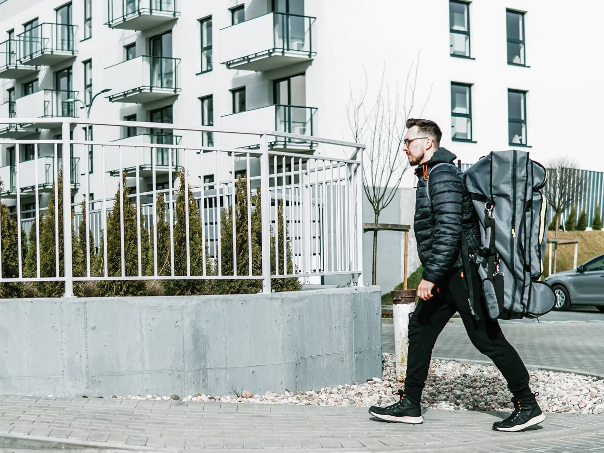 Masażysta idzie ulicą ze stołem do masażu w pokrowcu-plecaku Habys City