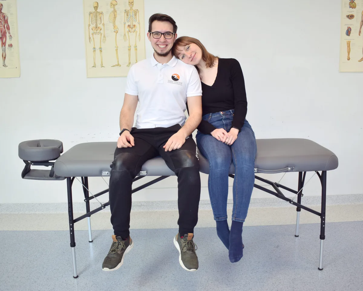 Dwie osoby siedzą na stole do masażu Luna Light, testując jego wytrzymałość